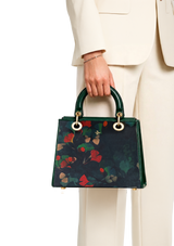 Person holding a floral handbag with a plain background